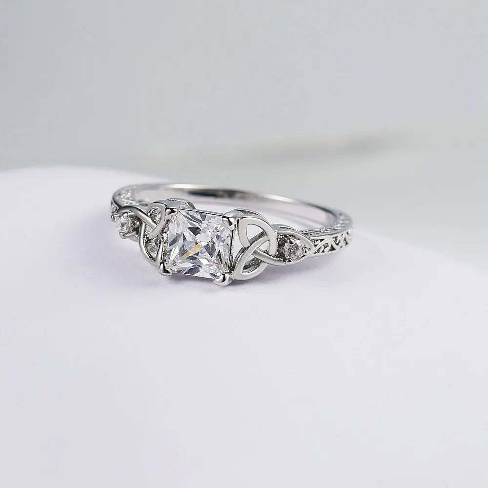 Anillo con diseño de nudo y piedra preciosa en el centro