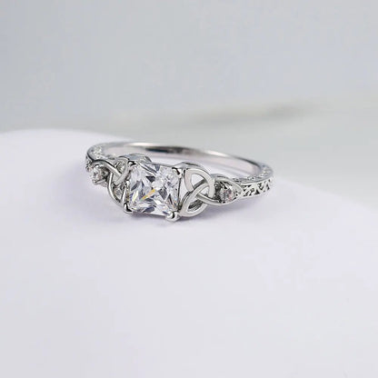 Anillo con diseño de nudo y piedra preciosa en el centro