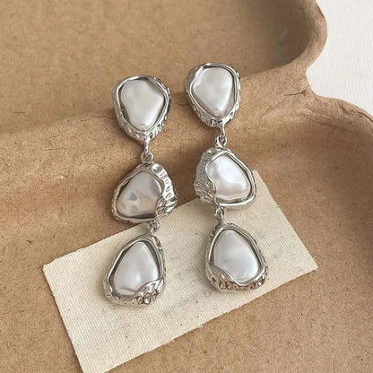 Aretes triangulares de plata con margaritas